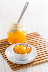 Image showing Lemon curd or fruit jelly in small bowl and glass jar on wooden background