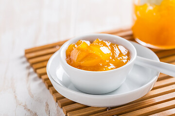 Image showing Lemon curd or fruit jelly in small bowl and glass jar on wooden background