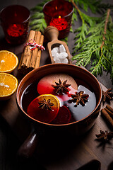 Image showing Spicy mulled wine with orange, apple, cinnamon and anise in pot