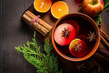 Image showing Spicy mulled wine with orange, apple, cinnamon and anise in pot