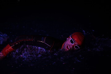 Image showing real triathlon athlete swimming in dark night