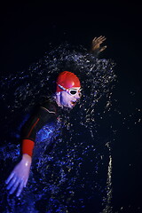 Image showing real triathlon athlete swimming in dark night