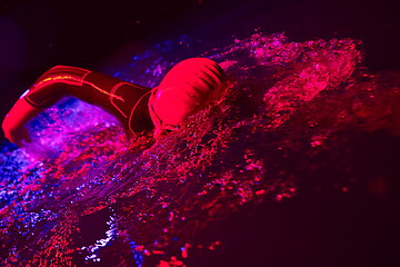 Image showing real triathlon athlete swimming in dark night