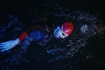 Image showing real triathlon athlete swimming in dark night