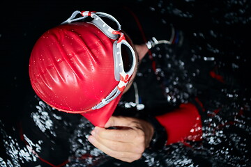 Image showing authentic triathlete swimmer having a break during hard training on night