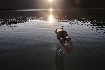 Image showing triathlon athlete jumping in to water and starting with training