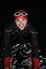 Image showing authentic triathlete swimmer having a break during hard training on night