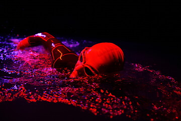 Image showing real triathlon athlete swimming in dark night