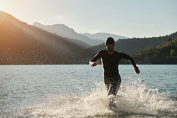 Image showing triathlon athlete starting swimming training on lake