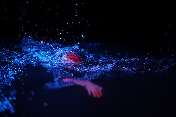 Image showing real triathlon athlete swimming in dark night