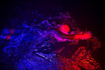 Image showing real triathlon athlete swimming in dark night