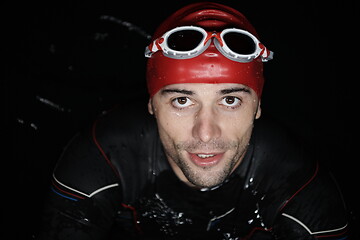 Image showing authentic triathlete swimmer having a break during hard training on night