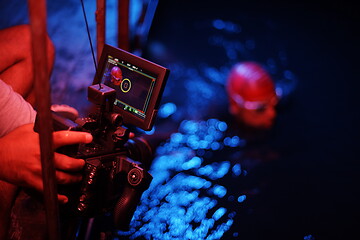 Image showing videographer taking action shot of triathlon swimming athlete at night