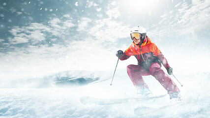 Image showing Young woman and winter sport - she is skiing against white alps mountains
