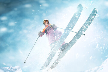 Image showing Young woman and winter sport - she is skiing against white alps mountains