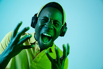 Image showing The young handsome hipster man listening music with headphones