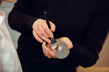 Image showing Professional makeup artist working with beautiful young woman