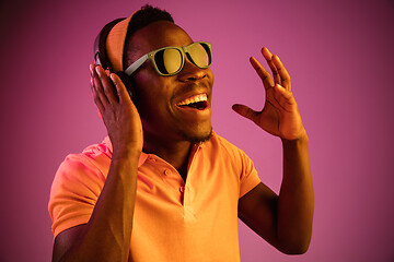 Image showing The young handsome hipster man listening music with headphones