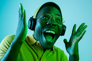 Image showing The young handsome hipster man listening music with headphones