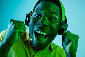 Image showing The young handsome hipster man listening music with headphones