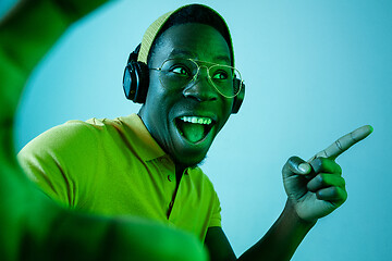 Image showing The young handsome hipster man listening music with headphones