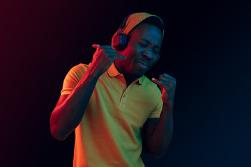 Image showing The young handsome hipster man listening music with headphones