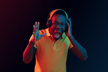 Image showing The young handsome hipster man listening music with headphones