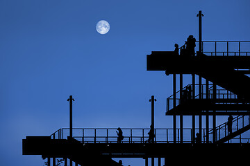 Image showing a passage of steel with people by night with moon