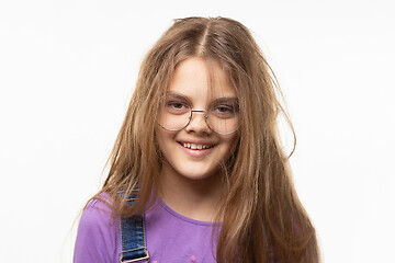 Image showing Portrait of a cheerful tousled long-haired girl of eleven years in glasses