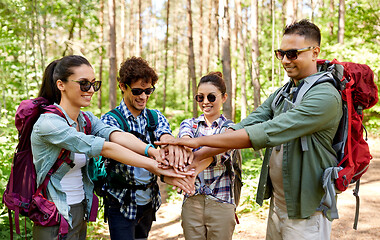 Image showing friends with backpacks stacking hands in forest