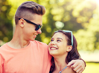 Image showing happy teenage couple looking at each other in park