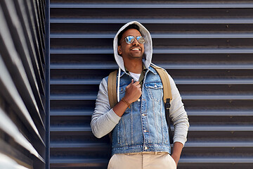 Image showing smiling indian man with backpack on city street