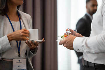 Image showing business people with conference badges and coffee