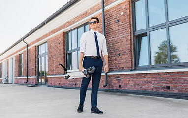 Image showing businessman with folding scooter on rooftop