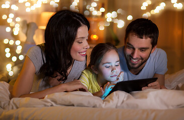 Image showing family with tablet pc in bed at night at home