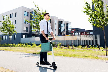 Image showing businessman with shopping bag riding scooter