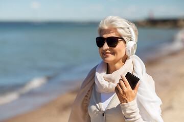 Image showing senior woman using smartphone on beach