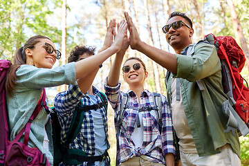 Image showing friends with backpacks hiking and making high five