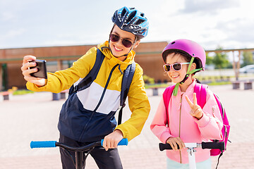 Image showing happy school kids with scooters taking selfie