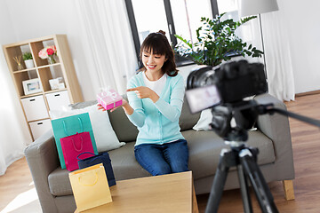 Image showing asian female blogger with gift bag recording video