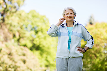 Image showing senior woman with earphones at summer park