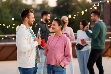 Image showing friends with drinks in party cups at rooftop