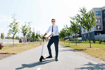 Image showing young businessman riding electric scooter outdoors