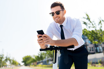 Image showing businessman with smartphone and electric scooter