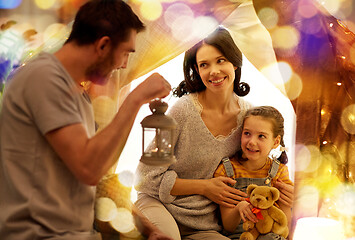 Image showing happy family playing in kids tent at night at home