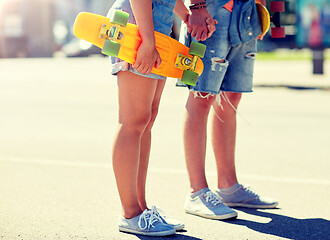 Image showing close up of young couple with skateboards in city