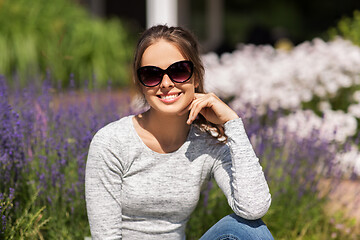 Image showing happy young woman in sunglasses at summer garden