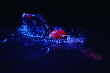 Image showing real triathlon athlete swimming in dark night