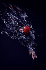 Image showing triathlon athlete swimming in dark night wearing wetsuit