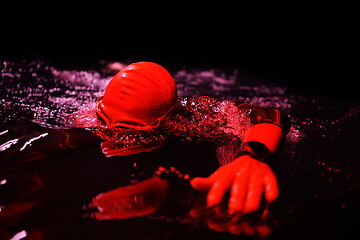 Image showing real triathlon athlete swimming in dark night